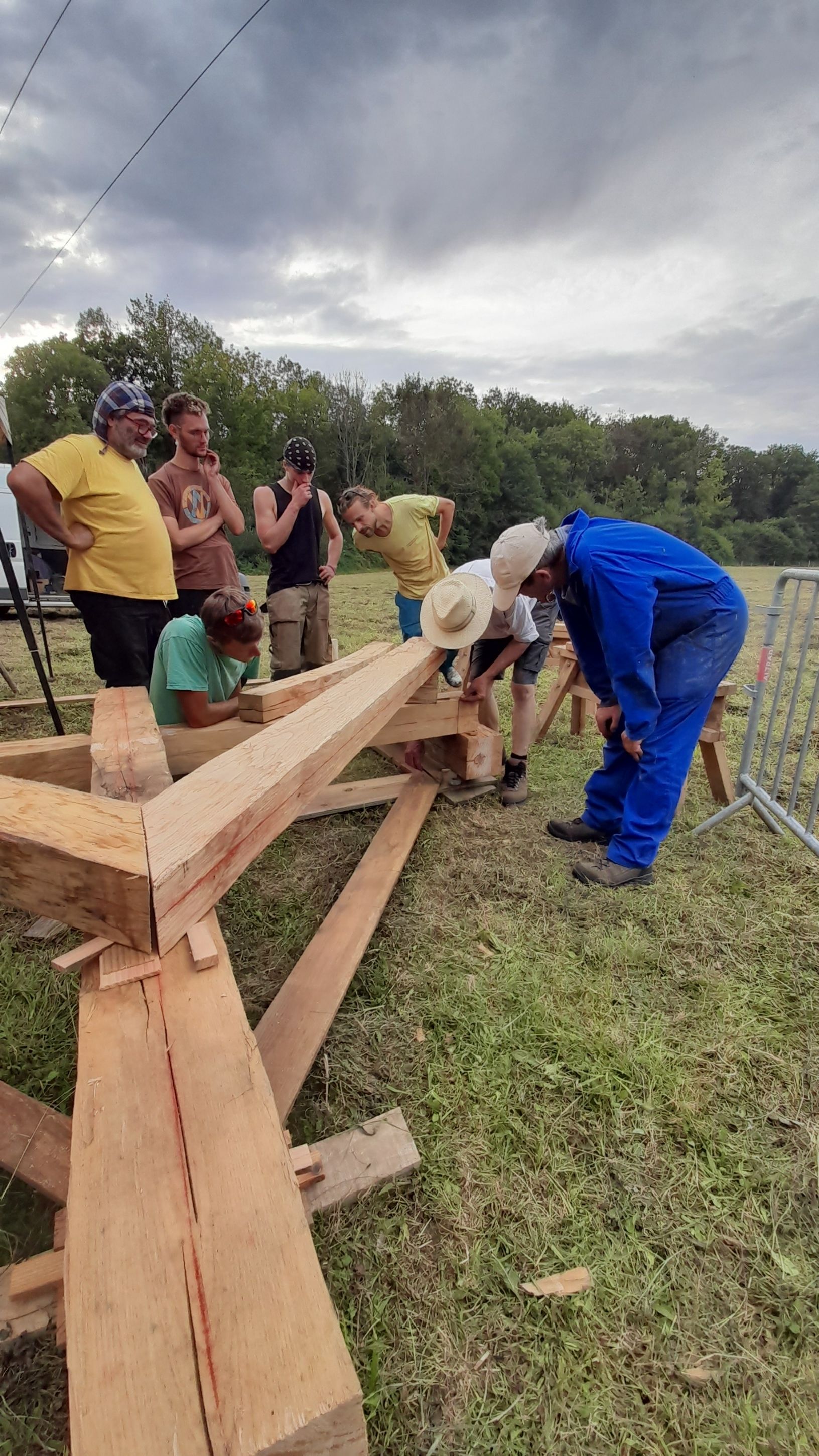 Atelier dessin, taille et assemblage de ferme sur poteaux en troncs de châtaigner équarris à la hache