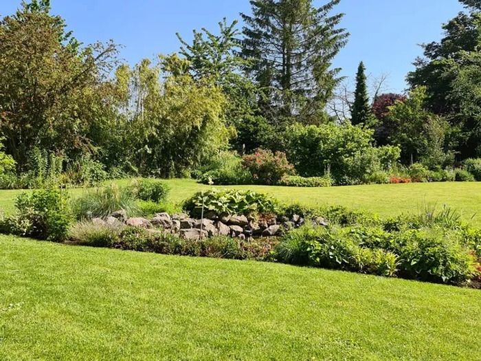 Führung durch einen leicht abfallenden Landschaftsgarten im englischen Stil mit einer Fläche von 4000 m2\. Die Massive sind in Mixed Borders organisiert. Sammlung von Hydrangea, Hémérocalles, Hostas,