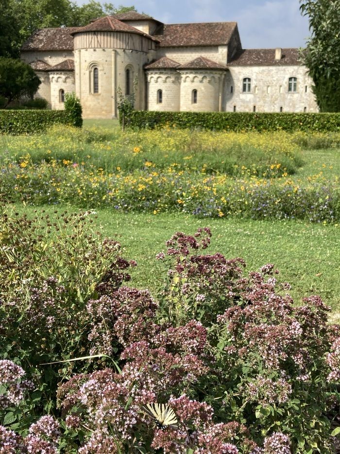 Entdecken Sie die Figur der Hildegard von Bingen in einem Fokus im Garten mit den Führern der Abtei Flaran.