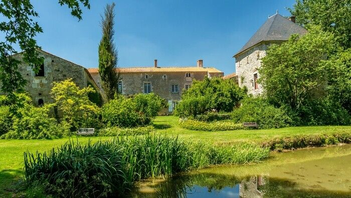 Rund um ein Vendée-Haus aus dem 17\. Jahrhundert führt eine Reihe von blühenden Höfen zum Flussufer, wo eine große orientalische Platane abschneidet.