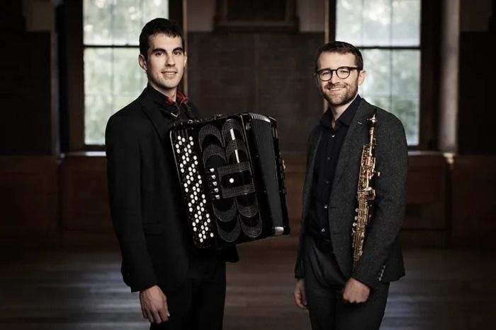Ce duo est formé par le saxophoniste canadien David Zucchi et l'accordéoniste espagnol Iñigo Mikeleiz-Berrade. Leur répertoire offre des œuvres traditionnelles revisitées, modernes et improvisées.