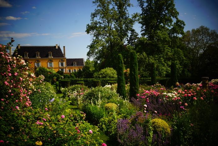 In einem romantischen Park mit schönen Bäumen, rund um ein elegantes Haus aus dem 17\. Jahrhundert, entdecken Sie einen geheimen Garten voller Charme, wo alte Rosen und Stauden aufeinander treffen.